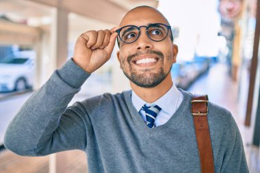 Genç Afrikalı Amerikalı iş adamı gülümseyerek şehirde mutlu bir şekilde yürüyor..