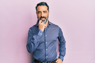 Orta yaşlı, sakallı, gri saçlı, iş kıyafetleri giyen, kameraya kendinden emin, kolları çapraz ve çenesi açık gülümseyen bir adam. Olumlu düşünmek. 