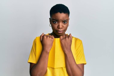 Genç Afrikalı Amerikalı kadın kitabı kuşkucu ve gergin tutuyor, sorun yüzünden surat asıyor. negatif kişi. 