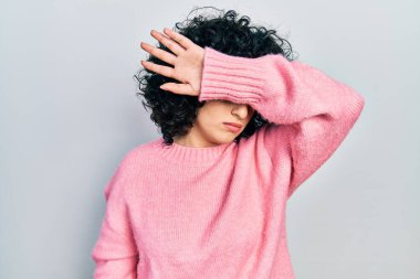 Orta Doğulu genç bir kadın, sıradan kıyafetler giyiyor, kollarıyla gözlerini kapatıyor, ciddi ve üzgün görünüyor. Görme, saklama ve reddetme konsepti 