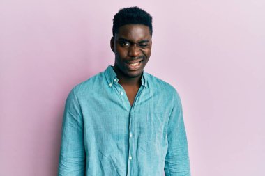 Yakışıklı, sıradan kıyafetler giyen, kameraya seksi bir ifadeyle bakan, neşeli ve mutlu yüzlü bir zenci.. 