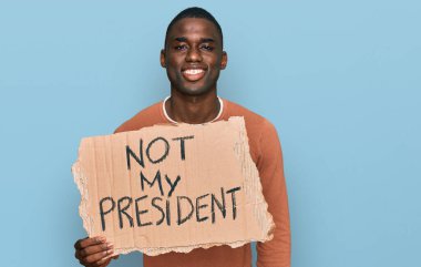 Genç Afro-Amerikan adam elinde benim başkanımın protesto pankartı değil. Pozitif ve mutlu görünüyor. Kendine güvenen bir gülümsemeyle dişlerini gösteriyor. 