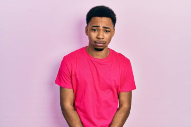 Casua tişörtü giyen genç Afro-Amerikan adam üzgün ve endişeli, sinirli ve korkmuş. hüzünlü ifade. 