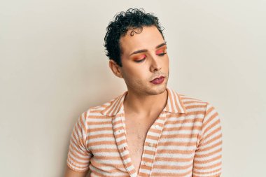 Makyaj yapan yakışıklı, sıradan bir gömlek giyen gururla bağıran, zaferi kutlayan ve kollarını kaldırarak heyecanlanan bir adam. 