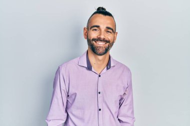 Yüzünde mutlu ve havalı bir gülümseme olan sıradan kıyafetler giyen genç İspanyol bir adam. şanslı kişi. 