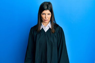 Genç İspanyol kadın yargıç üniforması giyiyor şüpheci ve gergin, sorun yüzünden surat asıyor. negatif kişi. 