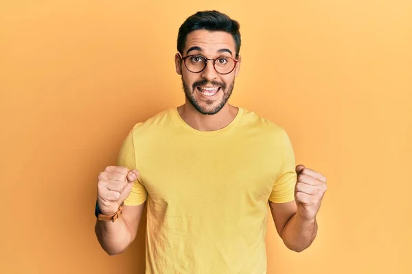 Ung Latinamerikan Man Bär Casual Kläder Och Glasögon Firar Förvånad — Stockfoto