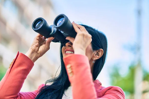 年轻美丽的女商人高兴地微笑着 用双筒望远镜在城里寻找新的机遇 — 图库照片