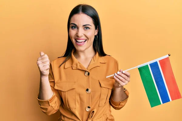 Joven Morena Sosteniendo Bandera Gambia Apuntando Con Pulgar Hacia Lado — Foto de Stock