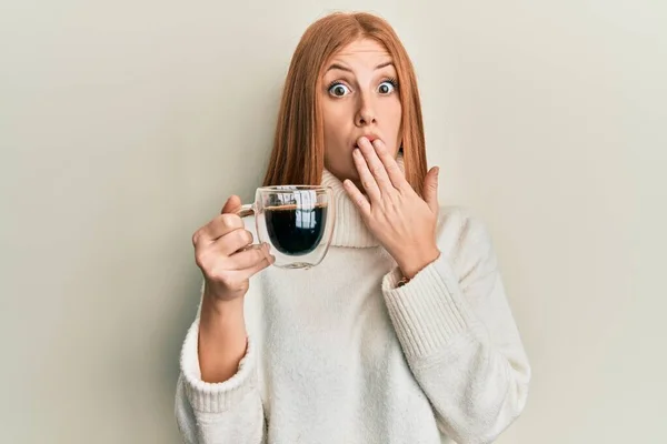 Młoda Irlandka Pijąca Filiżankę Kawy Zakrywającą Usta Dłonią Zszokowana Przerażona — Zdjęcie stockowe