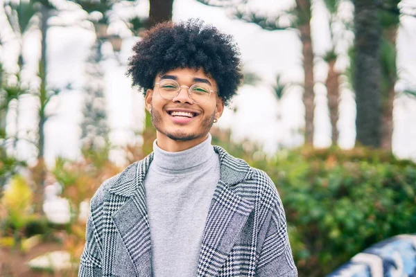 Genç Afrikalı Amerikalı işadamı parkta mutlu bir şekilde dikiliyor.