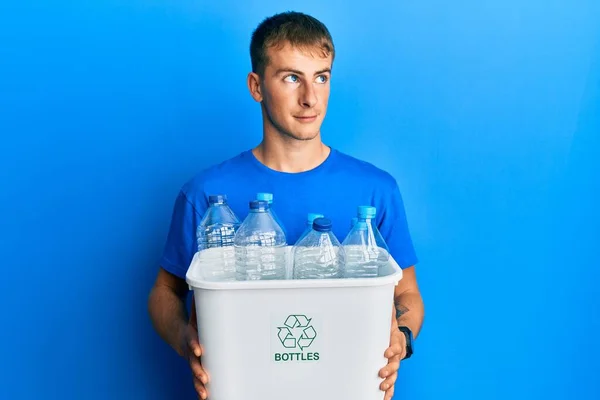 Jovem Caucasiano Segurando Lixo Reciclável Com Garrafas Plástico Sorrindo Olhando — Fotografia de Stock