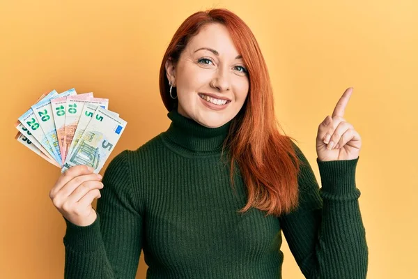 Avro Banknotları Tutan Güzel Kızıl Saçlı Kadın Gülümsüyor — Stok fotoğraf