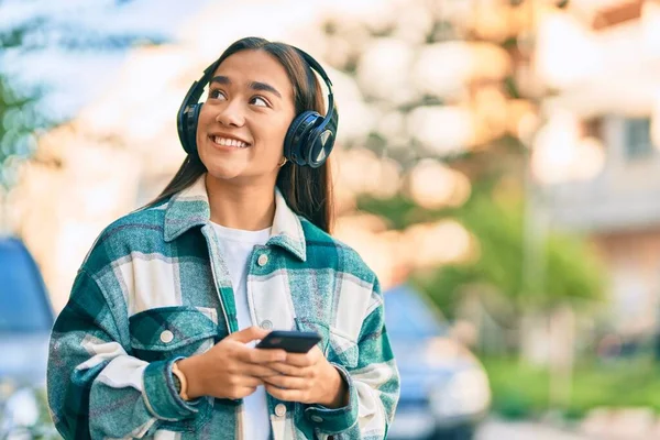 Νεαρή Λατίνα Κοπέλα Χαμογελώντας Ευτυχισμένη Χρησιμοποιώντας Smartphone Και Ακουστικά Στην — Φωτογραφία Αρχείου