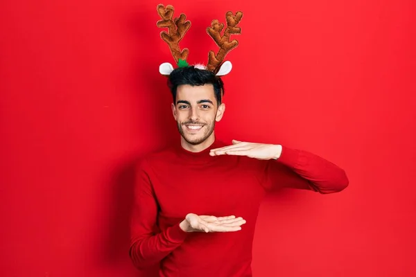 Νεαρός Ισπανόφωνος Άνδρας Φορώντας Χαριτωμένα Κέρατα Ταράνδου Χριστούγεννα Gesturing Χέρια — Φωτογραφία Αρχείου