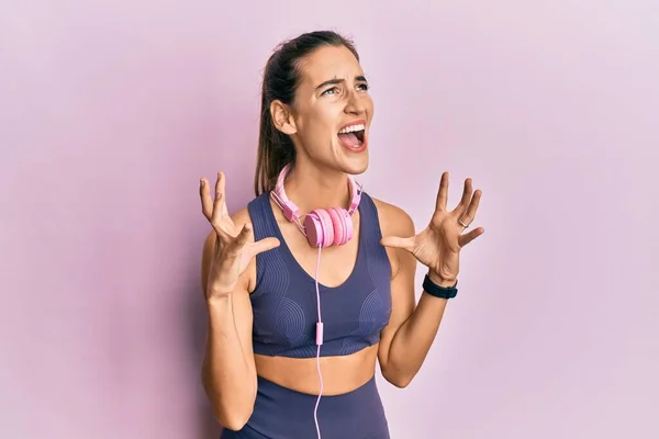 Young Beautiful Woman Wearing Gym Clothes Using Headphones Crazy Mad — Stock Photo, Image