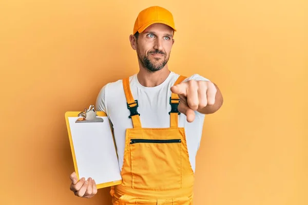 Joven Hombre Guapo Con Uniforme Mensajero Sosteniendo Portapapeles Sonriendo Mirando — Foto de Stock