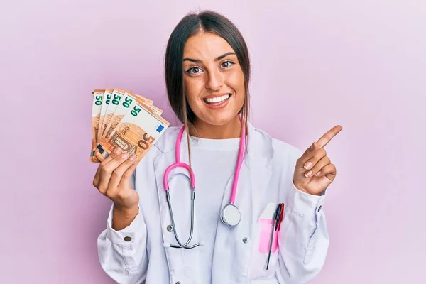 Mulher Hispânica Bonita Vestindo Uniforme Médico Segurando Notas Euros Sorrindo — Fotografia de Stock