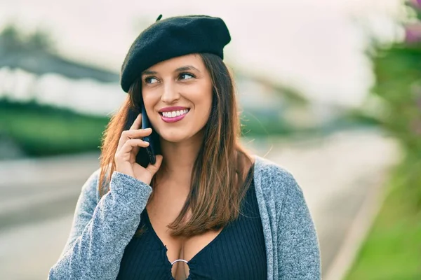 若いですラテン語の女性を身に着けていますフランス語スタイルを話す上のスマートフォンで市 — ストック写真