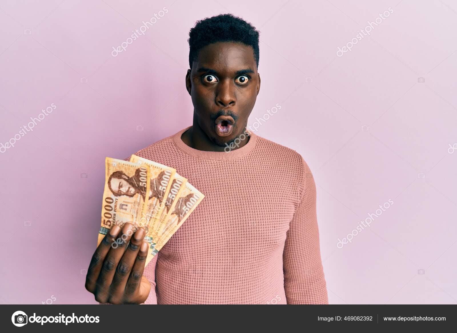 英俊的黑人手里拿着5000块饥饿的福林钞票吓得张大了嘴惊慌失措满脸诧异——图库图片© Krakenimages.com #469082392