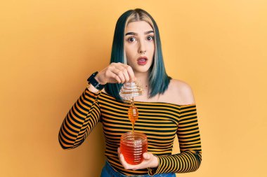 Şok olmuş, ağzı açık kalmış, kuşkucu ve alaycı görünen genç ve modern bir kız. 