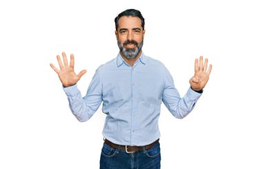 Orta yaşlı, sakallı, iş gömleği giyen, dokuz numaralı parmaklarıyla işaret eden, kendinden emin ve mutlu gülümseyen bir adam.. 