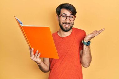 Genç İspanyol adam kitabı okuyor, başarıyı mutlu bir gülümsemeyle kutluyor ve kazanan el kaldırarak ifade ediyor. 