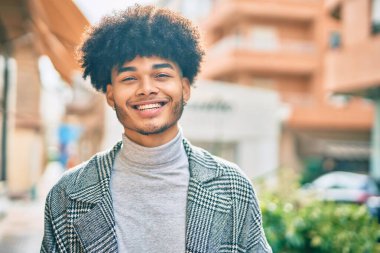 Genç Afrikalı Amerikalı iş adamı şehirde mutlu mesut dikiliyor..
