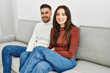 Genç İspanyol çift kanepede ve evde sarılıp dinleniyorlar..