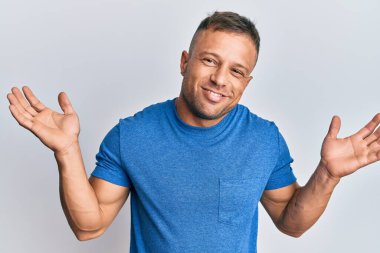 Yakışıklı, sıradan kıyafetler giyen, kafası karışık, kolları açık, hiçbir fikri olmayan, kuşkulu yüzlü bir adam.. 