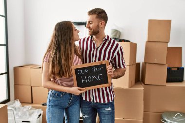 Yeni ev mesajımızla birlikte ellerinde tahtayla gülümseyen beyaz bir çift..