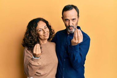 Orta yaşlı İspanyol çift gündelik giysiler giyer, elleriyle para jesti yapar, maaş ister, milyoner iş ister. 