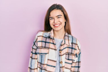 Yüzünde mutlu ve havalı bir gülümseme olan günlük kıyafetler giyen beyaz bir genç kız. şanslı kişi. 