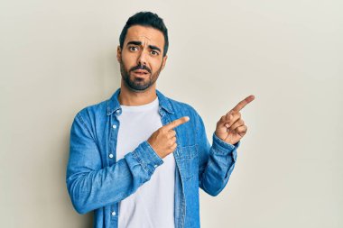 Genç İspanyol asıllı bir adam şok olmuş yüzünü göstererek şüpheci ve alaycı görünüyor, ağzı açık kalınca şaşırıyor. 