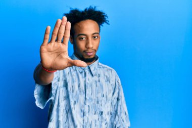 Sakallı, günlük kıyafetler giyen genç Afrikalı Amerikalı bir adam avucunun içi gibi şarkı söylemeyi kesiyor. Yüzünde olumsuz ve ciddi bir jest olan uyarı ifadesi. 