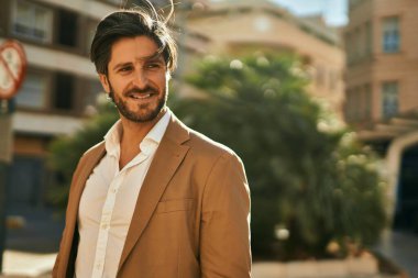 Genç İspanyol işadamı gülümseyerek şehirde mutlu mesut duruyor..