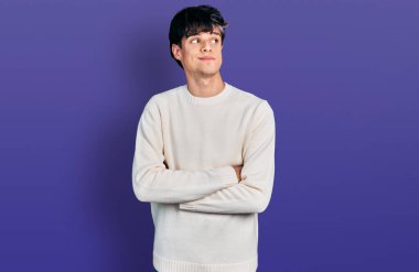 Yakışıklı hippi genç adam sıradan bir kazak giyiyor gülümsüyor yan bakıyor ve düşünüyor.. 