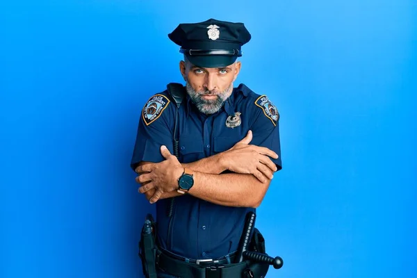 Middle age handsome man wearing police uniform shaking and freezing for winter cold with sad and shock expression on face
