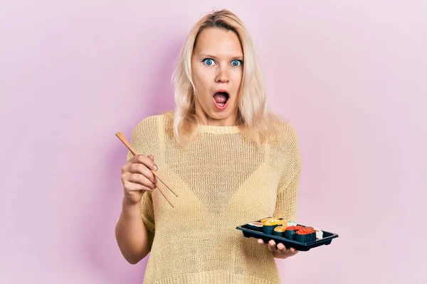 Hermosa Mujer Rubia Caucásica Comiendo Sushi Usando Palillos Asustada Sorprendida —  Fotos de Stock