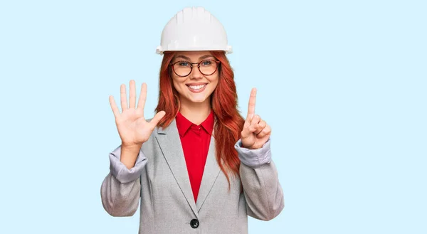 Junge Rothaarige Frau Mit Architektenhut Zeigt Und Zeigt Mit Finger — Stockfoto