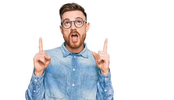 Young Redhead Man Wearing Casual Denim Shirt Amazed Surprised Looking — Stock Photo, Image