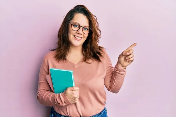 Joven Mujer Caucásica Sosteniendo Libro Sonriendo Feliz Señalando Con Mano — Foto de Stock