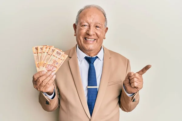 Hombre Caucásico Mayor Sosteniendo Pesos Mexicanos Sonriendo Feliz Señalando Con —  Fotos de Stock