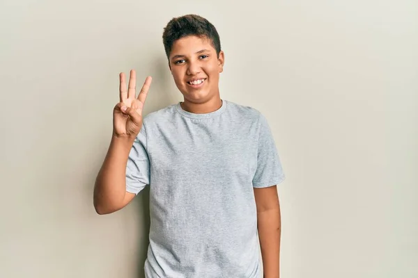 Подросток Латиноамериканец Обычной Серой Футболке Показывающий Пальцем Номер Три Улыбаясь — стоковое фото