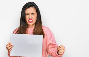 Boş pankart tutan güzel İspanyol kadın öfkeyle bağırıyor, öfkeyle bağırıyor, öfkeyle bağırıyor ve el kaldırıyor. 