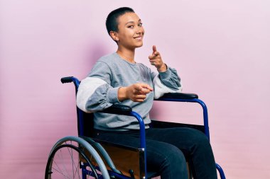 Tekerlekli sandalyede oturan, mutlu ve komik yüzlü İspanyol bir kadın. iyi enerji ve titreşimler. 