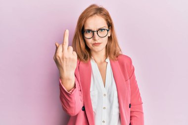 Young caucasian woman wearing business style and glasses showing middle finger, impolite and rude fuck off expression 