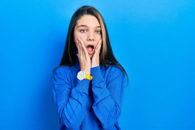 Balıkçı yaka kazak giyen genç esmer kız korkmuş ve şok olmuş, şaşırmış ve hayretler içinde kalmış. 