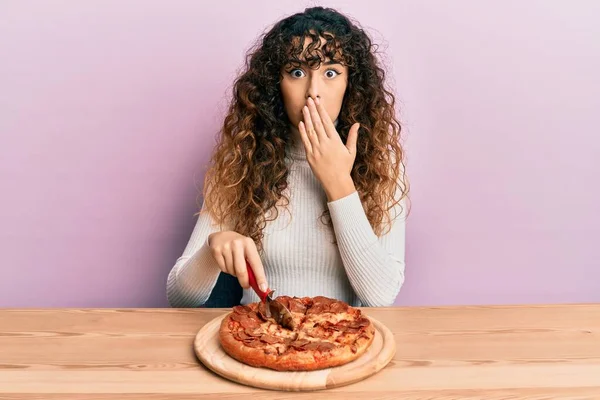 Menina Hispânica Jovem Cortando Saborosa Pizza Pepperoni Cobrindo Boca Com — Fotografia de Stock