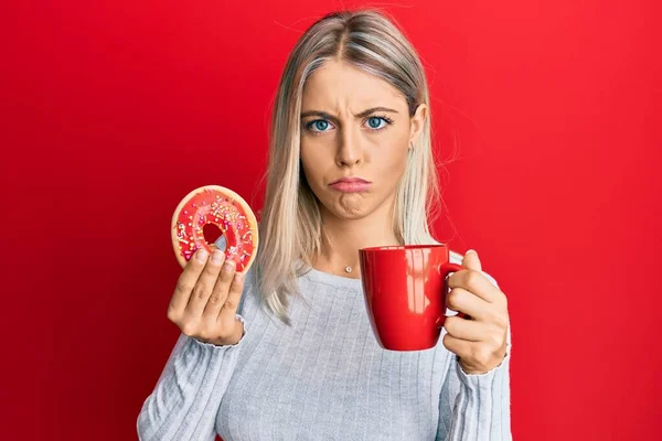 Mulher Loira Bonita Comer Donut Beber Café Deprimido Preocupar Com — Fotografia de Stock